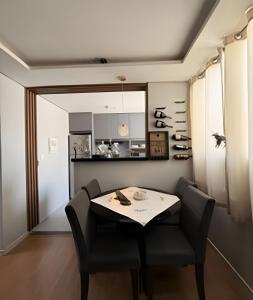 a dining room with a table and chairs and a kitchen at Safiras Premium | Seu conforto em Cuiabá in Cuiabá