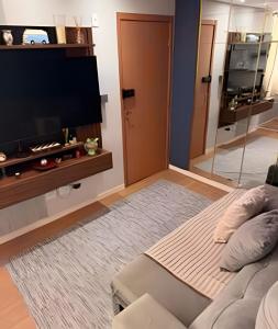 a living room with a flat screen tv and a couch at Safiras Premium | Seu conforto em Cuiabá in Cuiabá