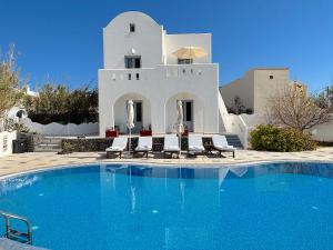 a villa with a swimming pool in front of a house at Villa Thea in Kamari