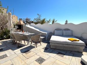 a patio with a bed and a table and chairs at Villa Thea in Kamari