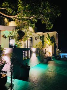 a house with lights on the side of it at night at Mango Tree House Yala Safari Hotel in Tissamaharama
