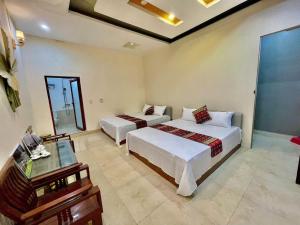 a hotel room with two beds and a table at Su Ha Giang Hostel in Ha Giang