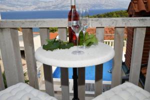 a bottle of wine on a table on a balcony at House Postira Horizon in Postira