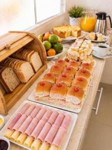 a table topped with different types of bread and pastries at Nova Perola de Guaruja in Guarujá