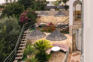 an outdoor patio with tables and chairs and umbrellas at Wiena Apartments in Ulcinj