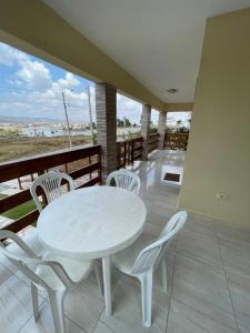a white table and chairs on a balcony with a view at Casa aconchegante em Bezerros- REI DAVID CONDOMÍNIO CLUBE in Bezerros