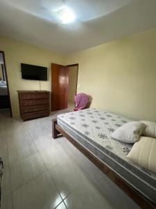 a bedroom with a bed and a flat screen tv at Casa aconchegante em Bezerros- REI DAVID CONDOMÍNIO CLUBE in Bezerros