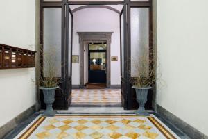 a hallway with two plants in vases and a door at Relais Hotel Centrale "Dimora Storica" in Florence