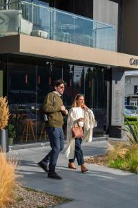 a man and a woman walking down a street at EHBoutique Experience in El Calafate