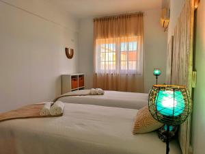 a room with three beds with a lamp on it at Sítio D'Elvas in Elvas