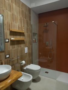 a bathroom with a toilet and a sink and a shower at Glamonia rooms in Campobasso +74 photos