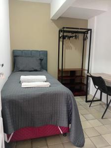 a bedroom with a bed and a desk and a mirror at Pousada e hostel Italia in São Luís