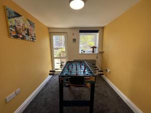 a room with a game table in the middle of it at Full Apartment in the Heart of Margate in Margate +10 photos