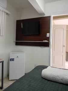 a bedroom with a bed and a tv on a wall at Pousada e hostel Italia in São Luís