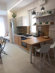 a kitchen with a wooden table and a stove at Glamonia rooms in Campobasso