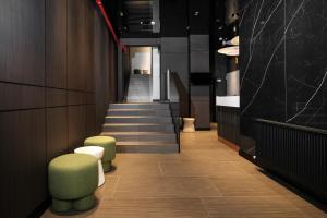 a hallway with stairs and green stools in a building at Ferdinand Boutique in Cluj-Napoca