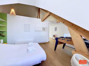 a room with a bed and a table in it at L'ancrage in Wimereux