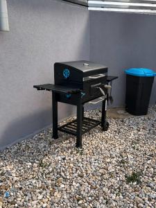 a grill sitting on a table with a trash can at Sasha Apartment and Swimming Pool in Gornje Selo