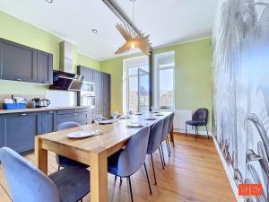 a dining room with a wooden table and chairs at L'ancrage in Wimereux
