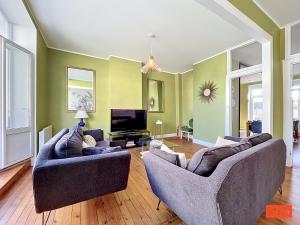 a living room with two couches and a tv at L'ancrage in Wimereux