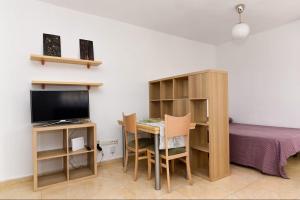 a small room with a desk and a bed and a table and a computer at Aprt ESTUDIO ARRIXACA in Murcia