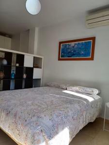 a bedroom with a bed and a painting on the wall at Aprt ESTUDIO ARRIXACA in Murcia