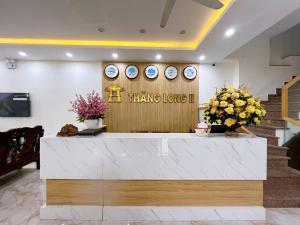 a lobby with a reception desk with clocks on the wall at Thăng Long II hotel FLC in Lôc Hải