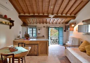 a kitchen and living room with a table and a couch at Il Maggese in Cortona