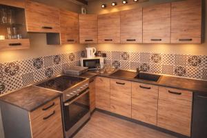 a kitchen with wooden cabinets and a stove top oven at Au Carnot in Douai +2 photos
