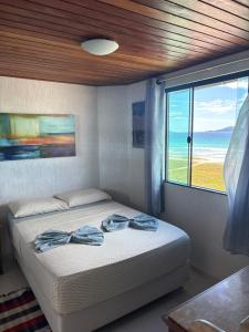 a bedroom with a bed and a large window at Pousada Casa do Telhado Verde in Cabo Frio +140 photos