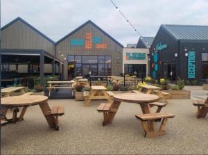 a group of picnic tables in front of a building at Diamond Touch Home in Saint Osyth