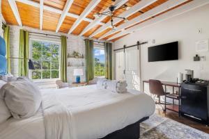 a bedroom with a large white bed and a desk at 4th Floor Queen Suite Boutique hotel in Savannah