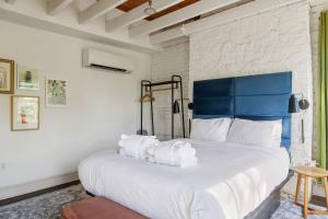 a bedroom with a large bed with a blue headboard at 4th Floor Queen Suite Boutique hotel in Savannah