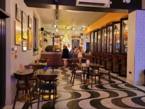 a restaurant with tables and chairs and people in the background at Diamond Touch Home in Saint Osyth