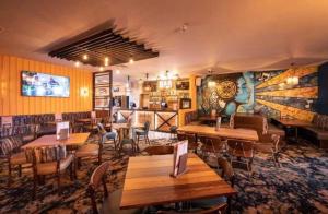 a restaurant with tables and chairs in a room at Diamond Touch Home in Saint Osyth