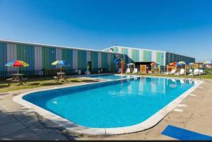 a large swimming pool in front of a building at Diamond Touch Home in Saint Osyth