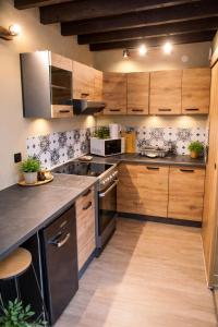 a kitchen with wooden cabinets and stainless steel appliances at Au Carnot in Douai
