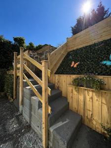 a set of stairs with a wooden fence at Sandytoes Cottage in Pentraeth