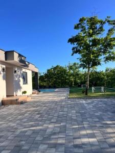 a parking lot with a tree and a building at Luxury Villa Grey in Široki Brijeg