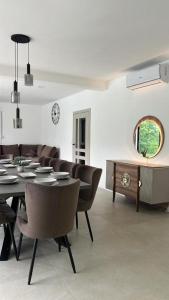 a dining room with a table and leather chairs at Luxury Villa Grey in Široki Brijeg
