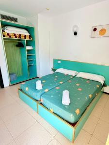 a bedroom with a blue bed with white towels on it at Apartments Lloret Sun in Lloret de Mar +18 photos