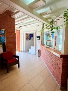 a room with a red chair and a brick wall at Apartments Lloret Sun in Lloret de Mar