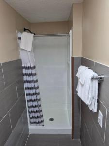 a shower in a bathroom with white towels at Wolcott inn and suites in Wolcott +4 photos