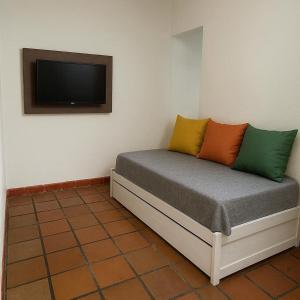 a bed with colorful pillows on it in a room at Casa Agrishow - locacao - bem proximo a feira in Ribeirão Preto