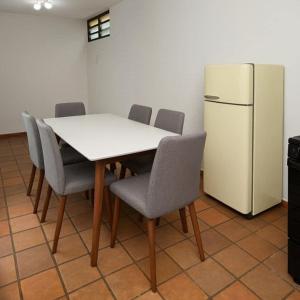 a kitchen with a table and a white refrigerator at Casa Agrishow - locacao - bem proximo a feira in Ribeirão Preto