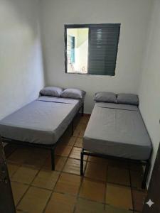two beds sitting in a room with a mirror at Casa Agrishow - locacao - bem proximo a feira in Ribeirão Preto