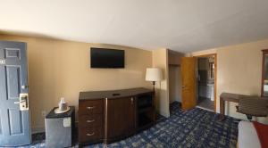 a hotel room with a television on the wall at Wolcott inn and suites in Wolcott