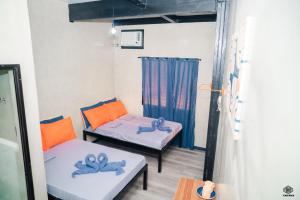 a room with two beds and a couch at Luna Vista Tourist Inn in Puerto Princesa City