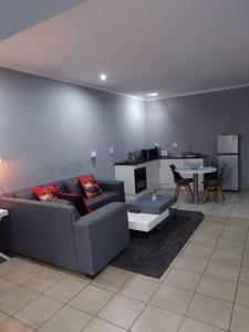 a living room with a couch and a table at Fullmoon Homes 9A in Edenvale