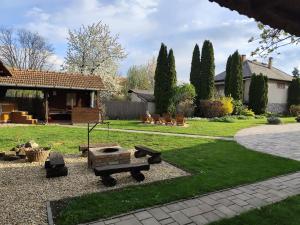 a backyard with a fire pit and a house at Bóbita Apartmanház in Szilvásvárad